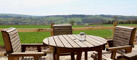 Private outdoor patio area with seating and barbecue at The Bus on The Hill holiday let in Devon.